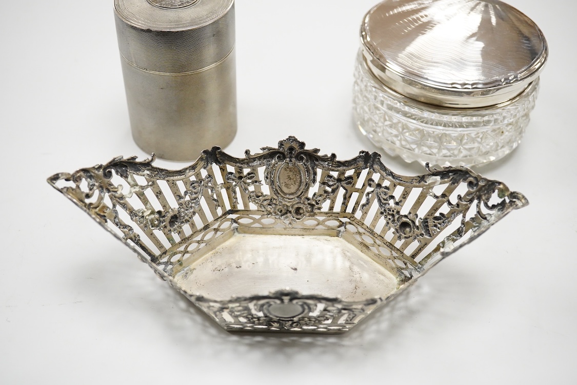 A German pierced 800 standard white metal bowl, 21.2cm, an engine turned white metal cigarette canister and a silver mounted glass dressing table pot.